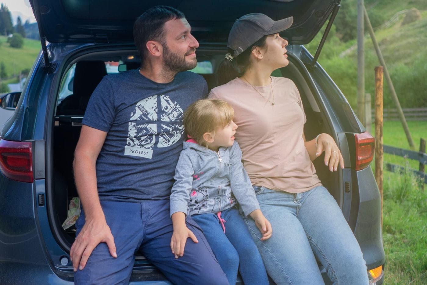 Une famille en voyage près de sa voiture